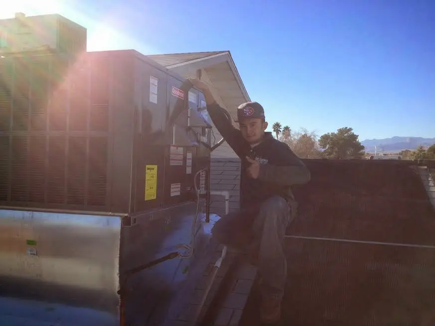 HVAC technician performing HVAC Inspection on a rooftop unit in Rotterdam